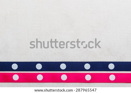 Festive celebration party frame. Polka dot navy blue and pink satin ribbon on white cloth background