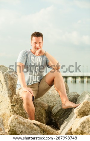 Happiness summer vacation and people concept. Fashion portrait handsome man full length on the stone beach landscape