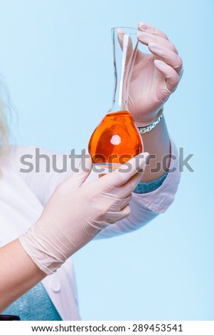 Experiment, research in progress. Chemist woman or student girl, laboratory assistant or scientific researcher with chemical glassware test flask on blue
