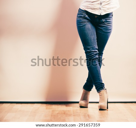 Fashion. Woman legs in denim trousers platform high heels shoes casual style studio shot, filtered photo