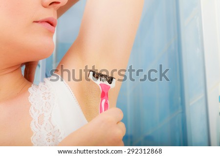 Hygiene skin care concept. Closeup woman shaving armpit with razor in bathroom