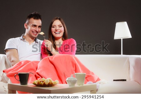 Smiling wife feeding happy husband with banana. Man and woman eating fruit. Healthy nutrition, dieting and slimming concept.