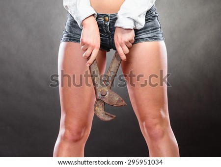 Closeup of sexy woman holding monkey wrench gas grips. Strong girl feminist working in man profession. Gender social issue.