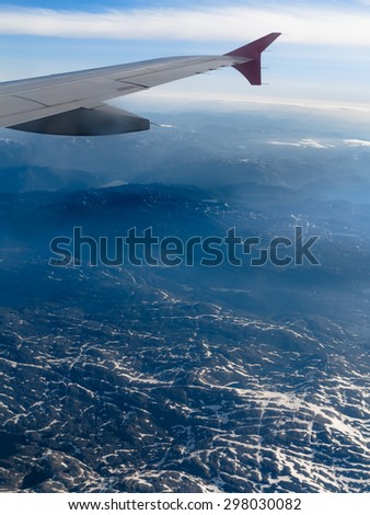 Birds eye. View from window of plane airplane flying over Norway Scandinavia, over snow covered Norwegian fjords