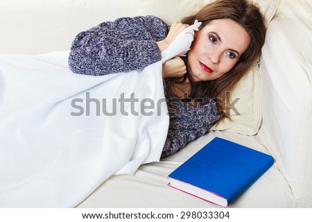 Health balance sleep deprivation concept. Sleeping woman on sofa. Girl lying on couch with book relaxed or taking power nap after lunch.