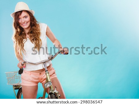 Active happy woman riding bike bicycle. Young girl in hat, white shirt and shorts. Healthy lifestyle and recreation leisure activity. Studio shot.