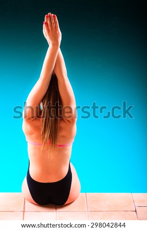 Sport active lifestyle. Sporty woman female swimmer muscular fit body preparing to jump into swimming pool back view