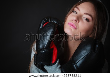 Martial arts or self defence concept. Sport boxer woman in gloves. Fitness girl training kick boxing on black background