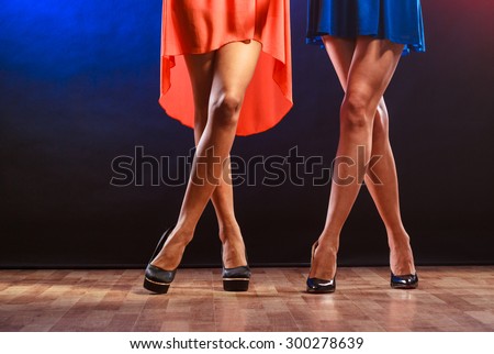 Party, celebration, disco concept. Women in evening dresses dancing in the club, part of body female legs in high heels on party floor.