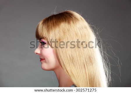 woman face profile with makeup and long blond hair on gray background