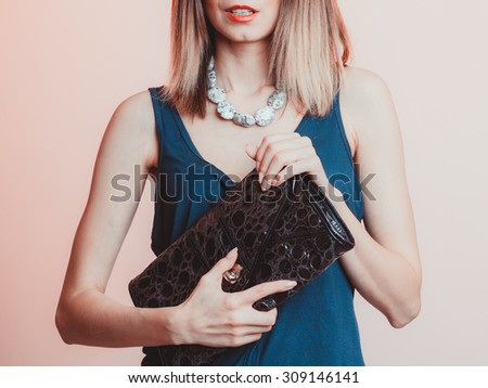 Elegant fashionable woman with leather handbag. Stylish girl holding black bag. Female fashion vogue. Studio.