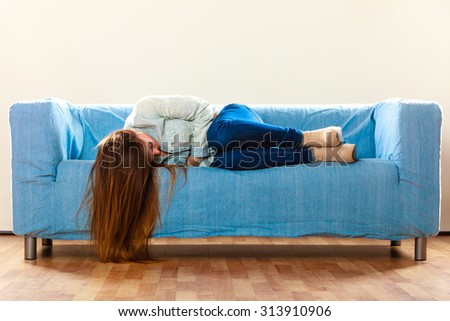 Loneliness negative emotion concept. Young sad stressed woman lying on couch at home