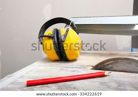 Improvement renovation at home. Construction site work tools saw blades cutter to cut tile, protective headphones noise muffs