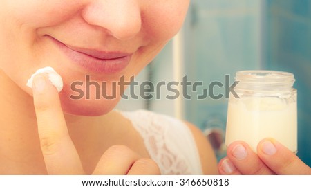 Human applying cleansing moisturizing skin cream on face. Person taking care of dry complexion layering moisturizer. Skincare. Instagram filter.
