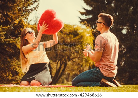Love romance dating relationship leisure concept. Couple playing games in park. Girl and her man passing heart spending time on picnic.