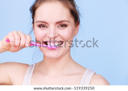 Woman brushing cleaning teeth. Girl with toothbrush. Oral hygiene. Blue background