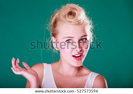 Face expression, emotions concept. Young woman with pin up hair being astonishment, shocked and disgust. Studio shot on green background