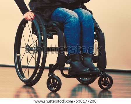 Disability and handicap concept. Young teen handicapped girl sitting on wheelchair. Paralysis and impairment in real life.