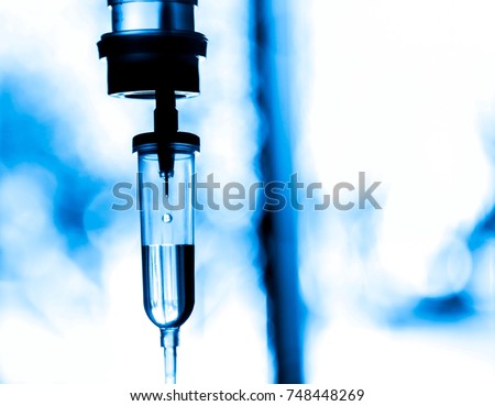 Saline iv bag intravenous drip hospital room,Medical Concept,treatment patient emergency and injection drug infusion care chemotherapy concept.blue light background hospital,Selective focus