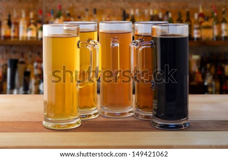 beer flight of five sampling mugs of light and dark craft beer in a bar