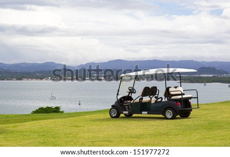 parked golf cart facing water reservoir with dramatic cloudy sky