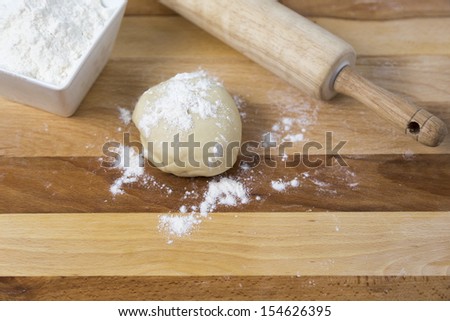 ball of dough with flour and a rolling pin