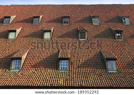 old pitched red tile roof with tiny garret casement widows