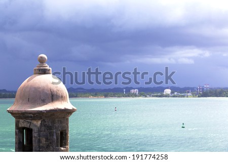 Historic Spanish watchtower overlooking San Juan Bay with dramatic stormy sky
