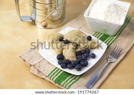 small plate full of Polish pierogi with blueberry filling
