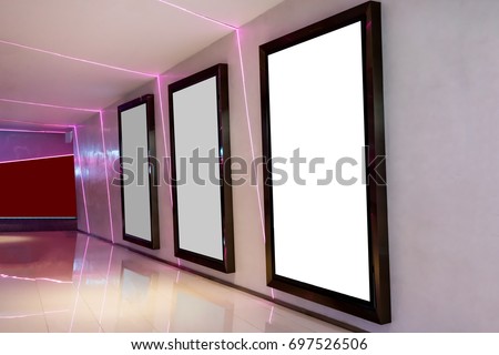 Three movie poster frames along the walkway in modern interior design for movie theater