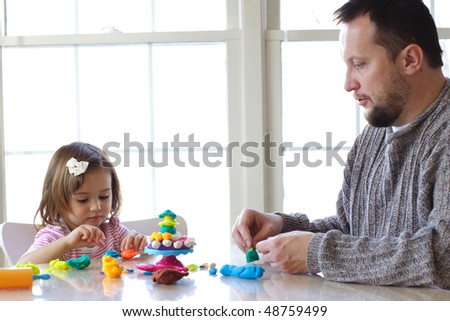 Little girl and father creating toys from play dough