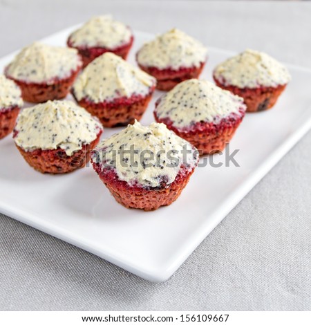 Delicious, mini sized, gluten free, red beetroot cupcakes. Butter and cream cheese topping with vanilla and poppy seeds. creative and colorful.