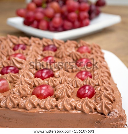 Gluten free chocolate cake with fancy topping. Chocolate cream and grapes. Home made.