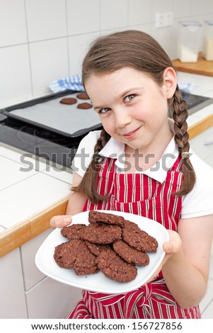 Cute little girl showing off the cookies she just made.