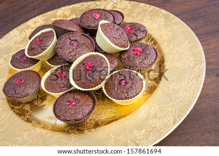 Whole bunch of chocolate muffins with cranberries on a golden plate. Home baked gluten free and delicious.
