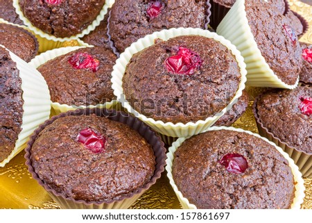 Whole bunch of chocolate muffins with cranberries on a golden plate. Home baked gluten free and delicious.