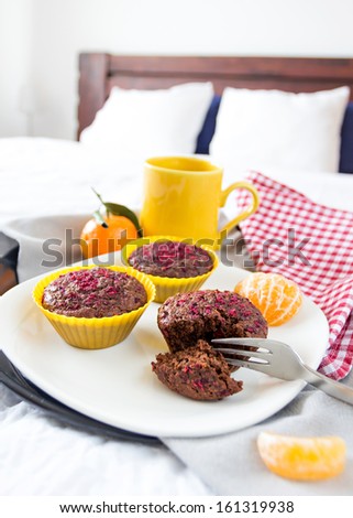 Breakfast tray with chocolate muffins, mandarin oranges and coffee or tea served in bed