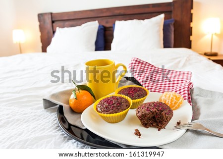 Breakfast tray with chocolate muffins, mandarin oranges and coffee or tea served in bed
