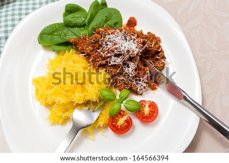 Serving of home cooked meal. Meat sauce with spaghetti squash, spinach and tomato. Colorful and low carb. Healthy food.
