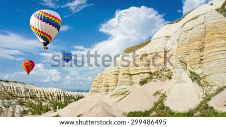Hot air balloons flying over Love valley at Cappadocia, Anatolia, Turkey. Volcanic mountains in Goreme national park.