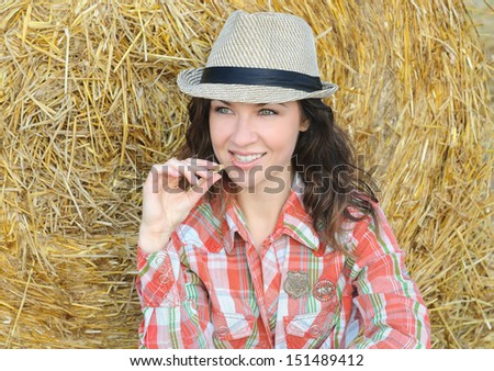 Portrait of young beautiful women near haystack in the field on sunrise