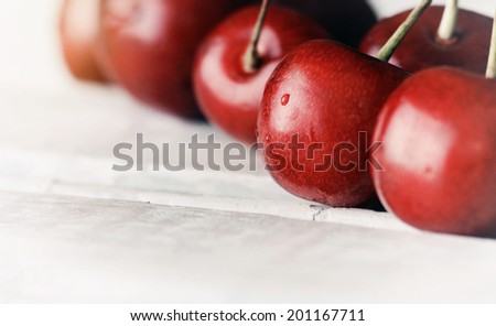 sweet ripe cherries on white wooden vintage table with water drops macro background