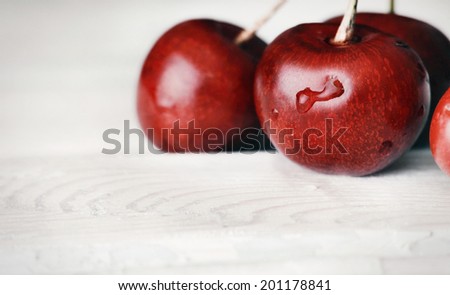 sweet ripe cherries on white wooden vintage table with water drops macro background