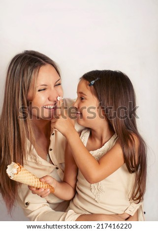 family of mother and doughter having fun with sweet cream puff, happy family concept
