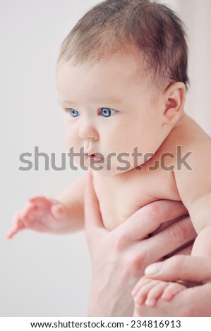 cute newborn baby in safe father\'s hands looking outside through the window, happy family concept, helthy baby