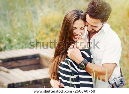 happy romantic couple in love and having fun with daisy at the lake outdoor in summer day, beauty of nature, harmony concept