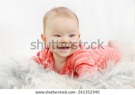 very happy cute little girl with wide smile on the white sofa