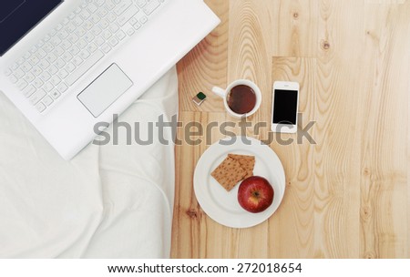 modern still life of morning breakfast routine work place with computer device, stuff and some snack, lifestyle concept