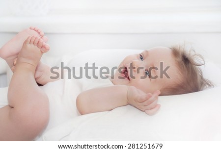 cute little happy baby boy lying on soft white pillow, happy family concept