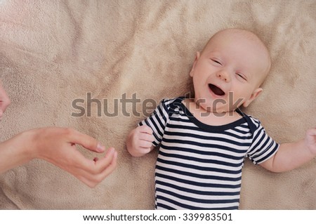 funny newborn boy singing song under care mother; singing cute newborn baby; maternity concept; soft image of beautiful family